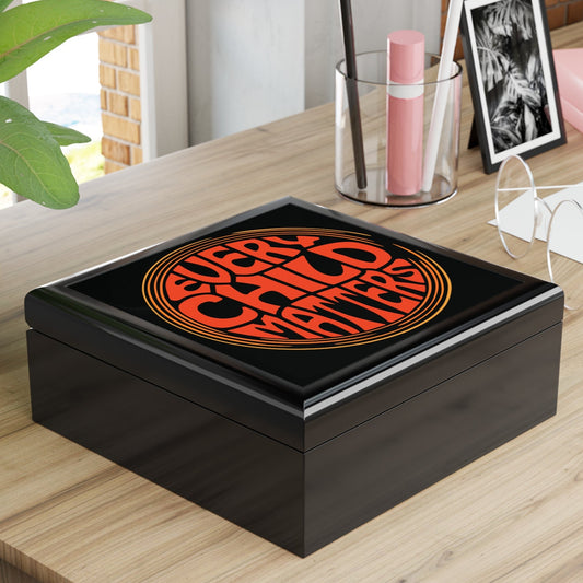 Black box with orange design on a wooden surface