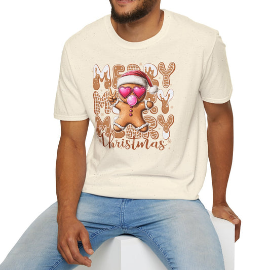 Man wearing a cream t-shirt with a Christmas design, sitting on a white stool against a white background.