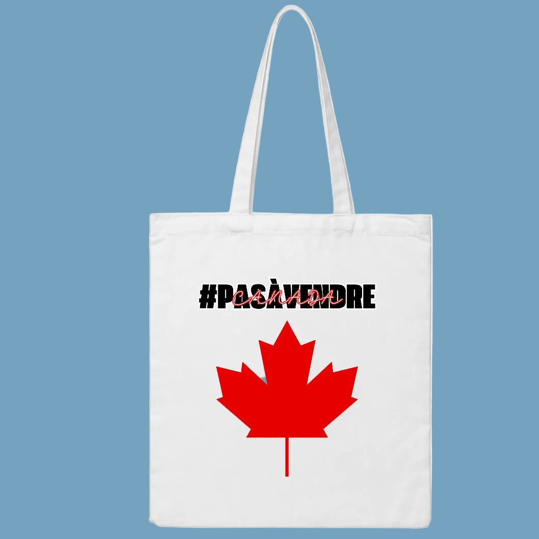 White tote bag with red maple leaf and black text on a blue background