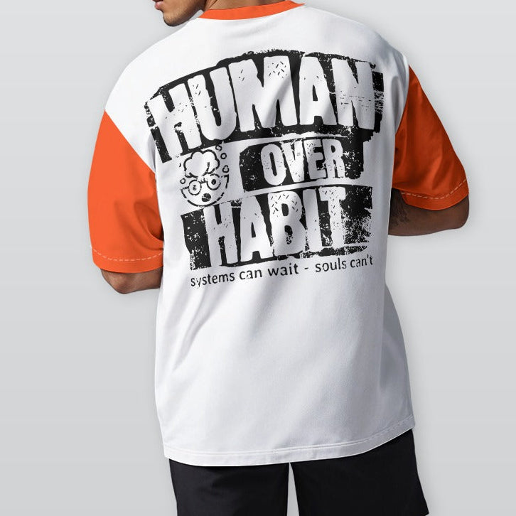 Person wearing a white and orange t-shirt with 'Human Over Habit' text on the back, standing against a plain background.