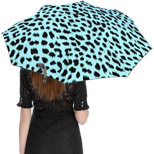 Person holding a leopard print umbrella with a light blue background