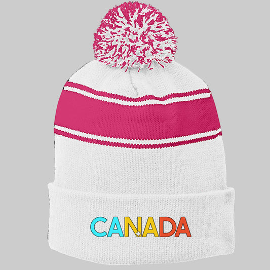 White knit beanie with pink top and colorful 'CANADA' text on a white background