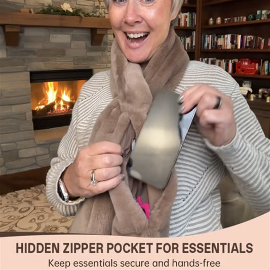 Woman wearing a scarf with a hidden zipper pocket in a cozy room with a fireplace.