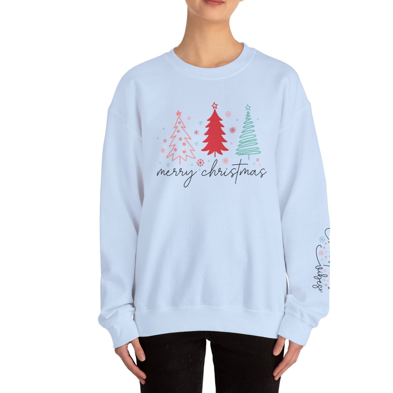 Light blue sweatshirt with Christmas tree design and 'merry christmas' text worn by a person on a white background