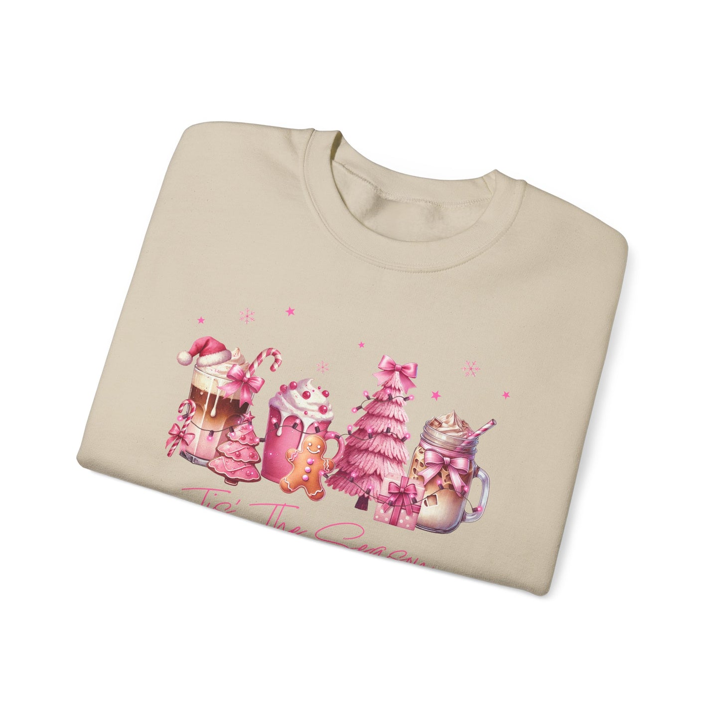 Folded sand sweatshirt with pink Christmas-themed design on a white background