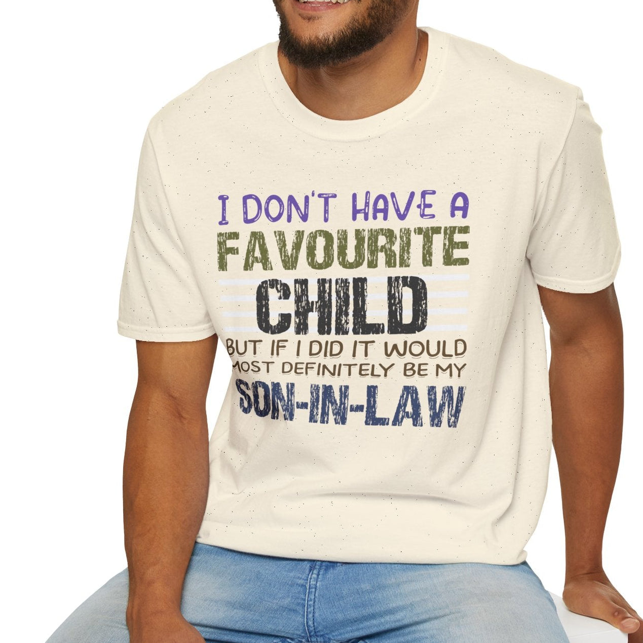 Man wearing a natural t-shirt with a humorous message sitting on a white stool.