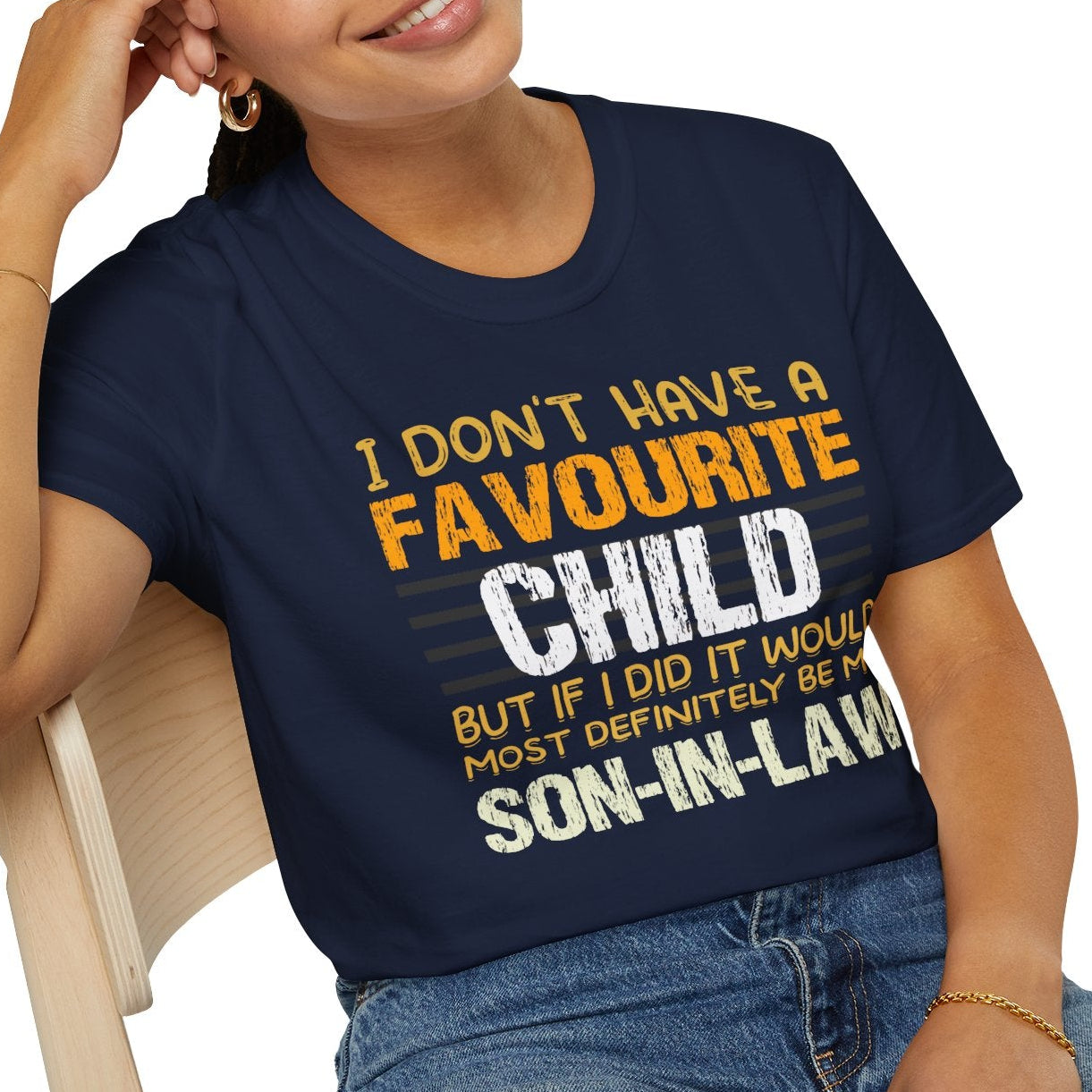 Person wearing a navy blue t-shirt with humorous text design, sitting on a white background.