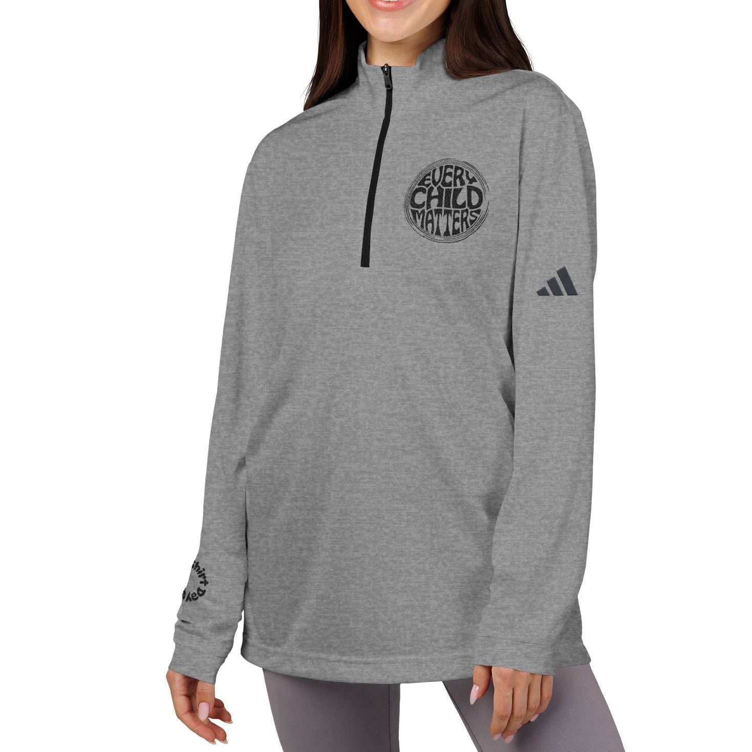 Woman wearing a gray Adidas sweatshirt with a logo on a white background