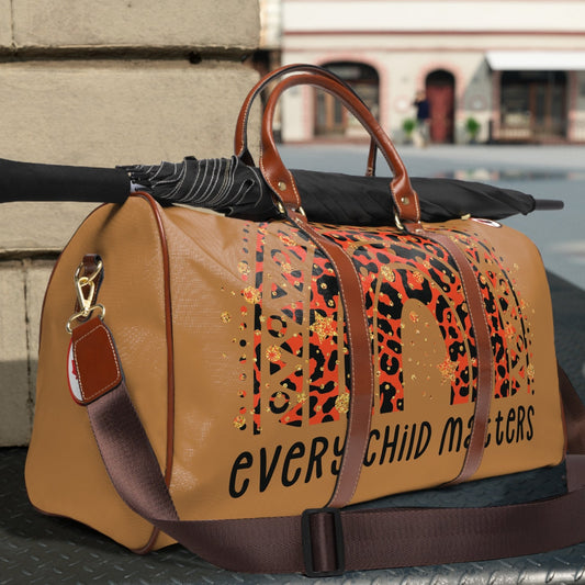 Brown duffel bag with 'Every Child Matters' text and leopard print design on a table outdoors.