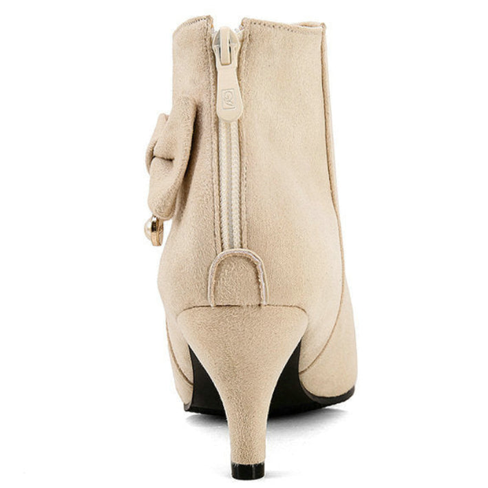 Cream ankle boot with a bow detail on a white background