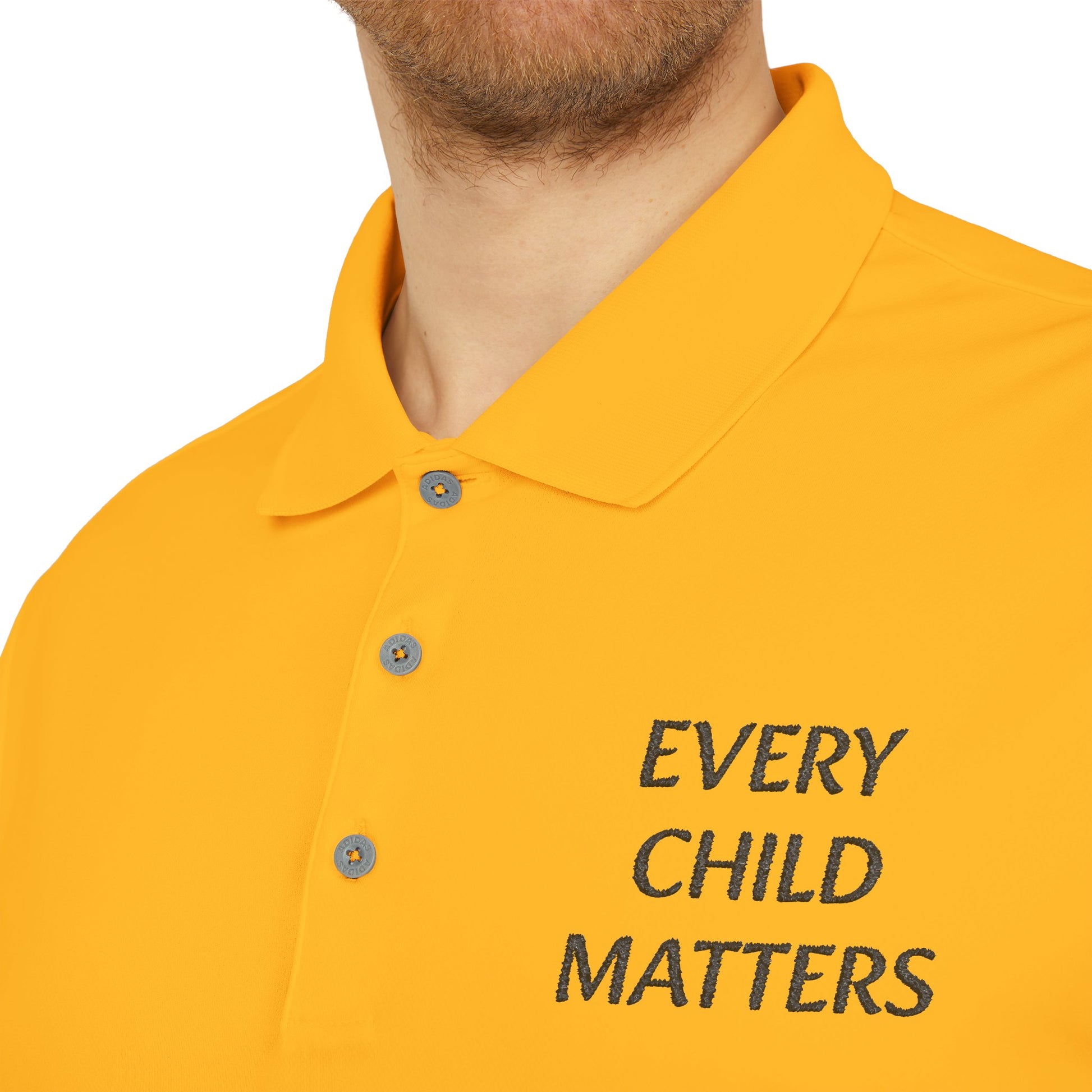 Close-up of a man wearing a bright yellow polo shirt with the text 'EVERY CHILD MATTERS' embroidered in black on the chest, on a white background.