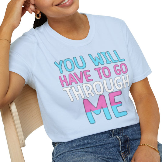 Person wearing a light blue t-shirt with colorful text, sitting on a chair against a white background