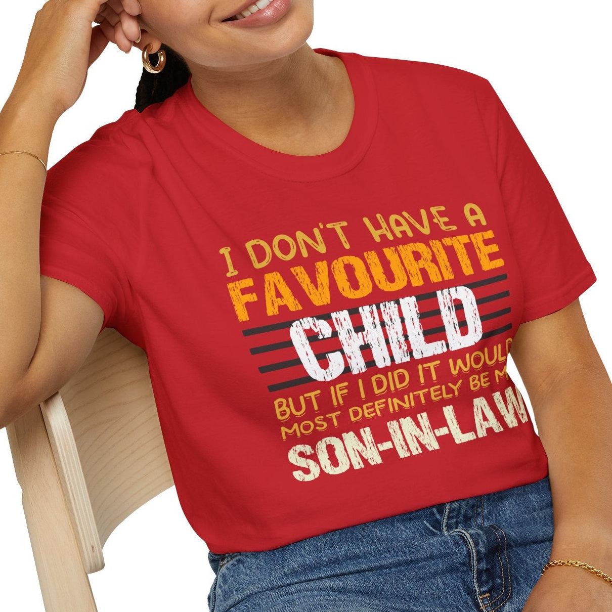 Person wearing a red t-shirt with humorous text design, sitting on a chair.