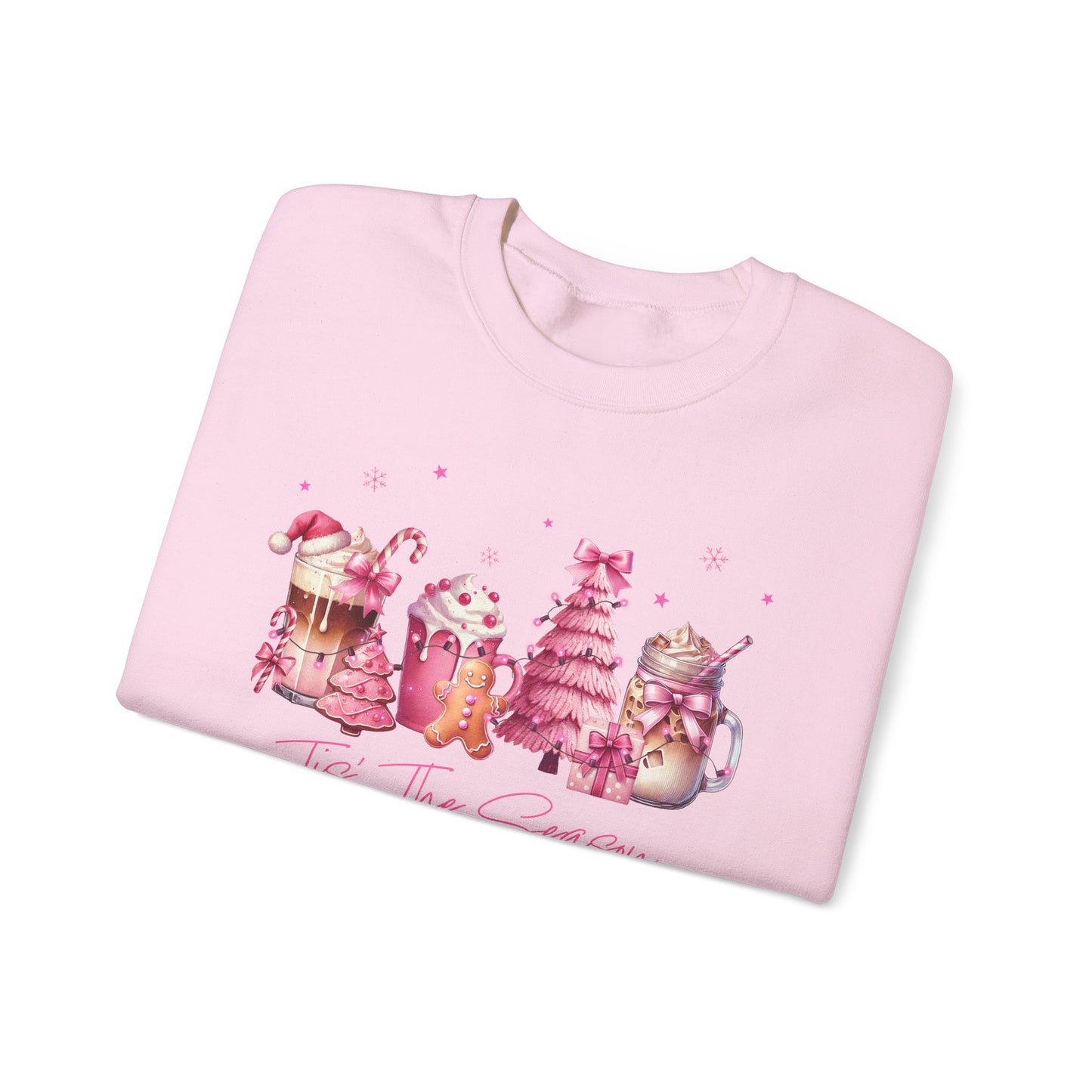 Folded pink sweatshirt with Christmas-themed design on a white background