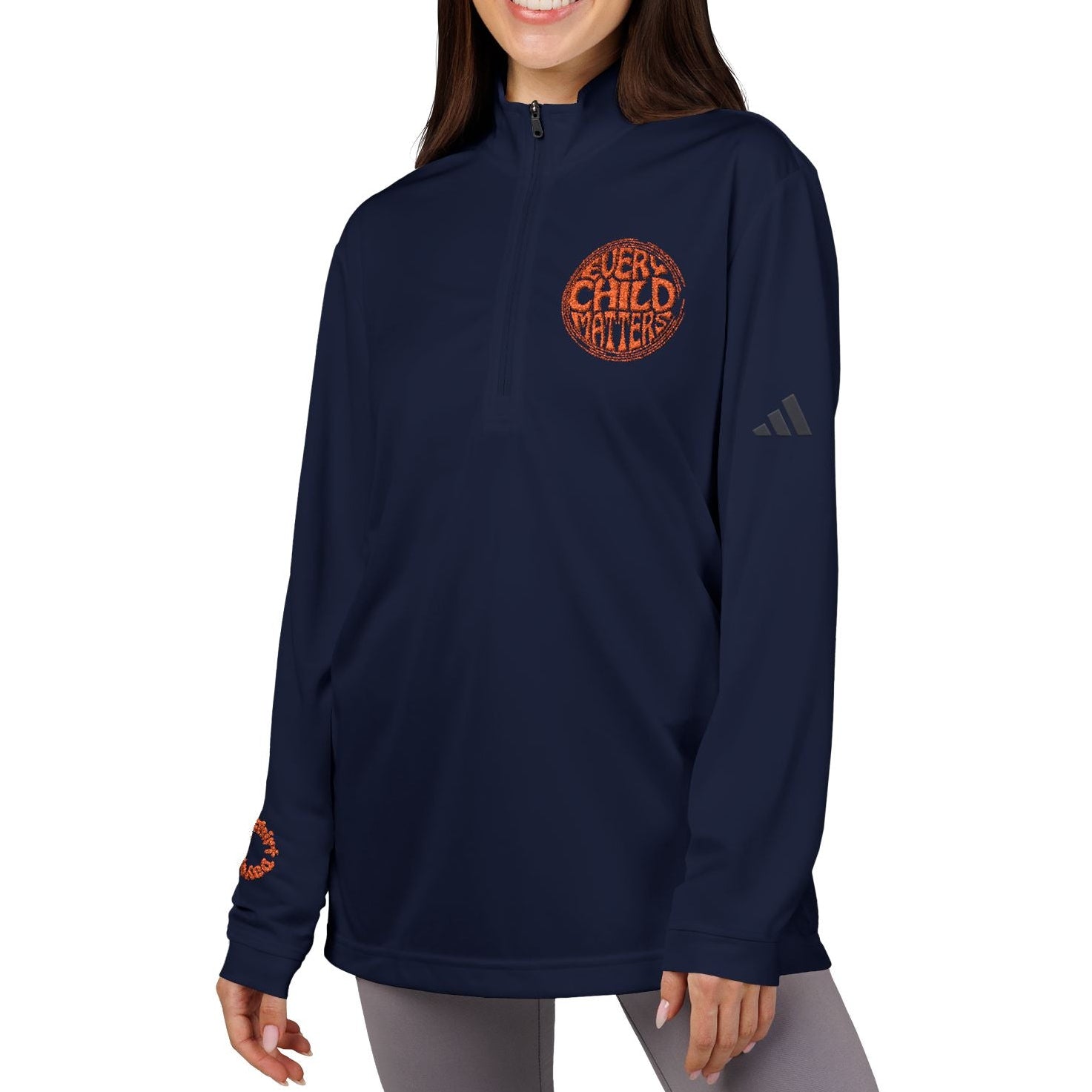 Woman wearing a navy blue Adidas sweatshirt with orange text on a white background