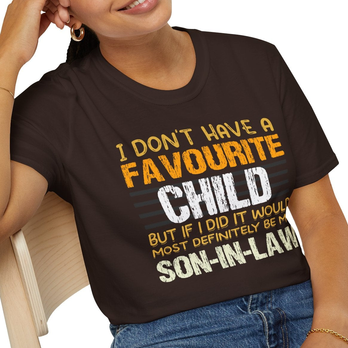 Person wearing a brown t-shirt with humorous text design, sitting on a chair.