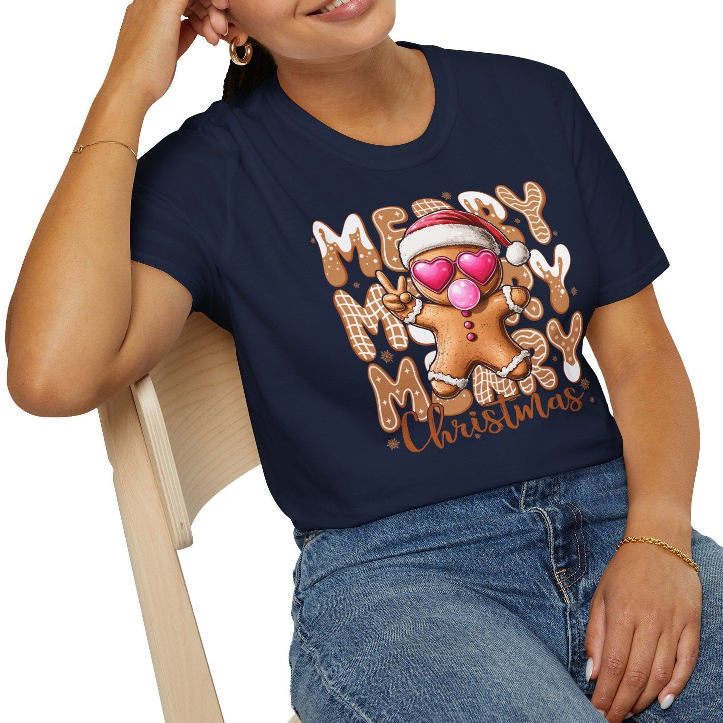 Woman wearing a navy blue t-shirt with a Christmas design, sitting on a white background