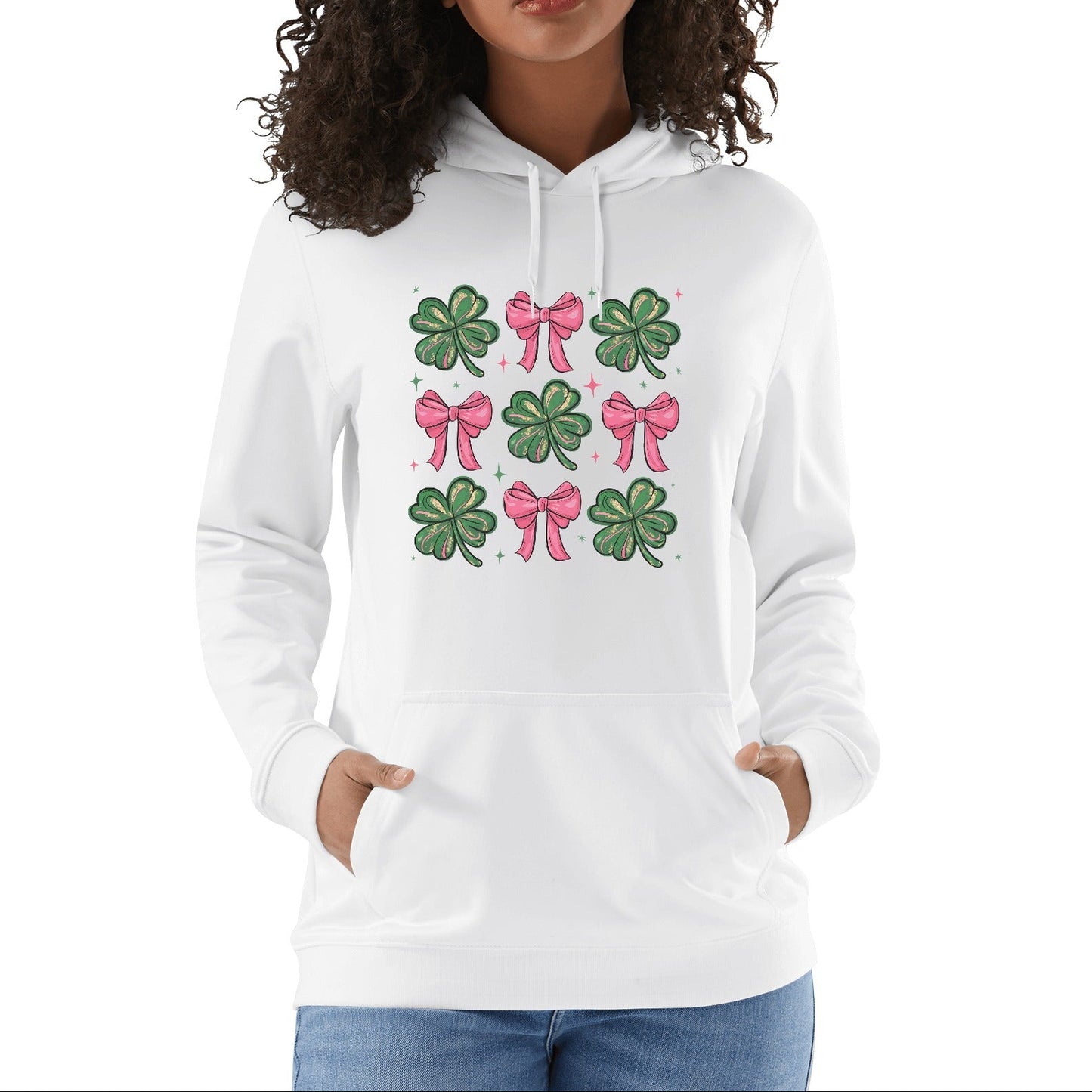 A person wearing a white hooded sweatshirt with a graphic design of clovers and bows in green and pink on the front.