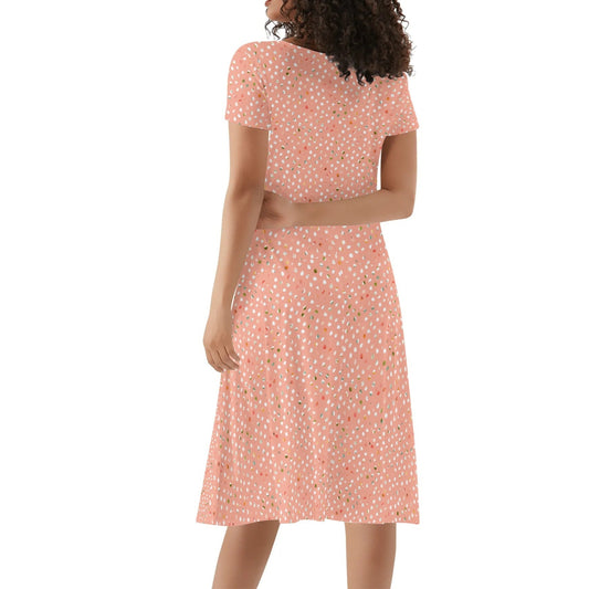 Woman wearing a peach floral dress on a white background