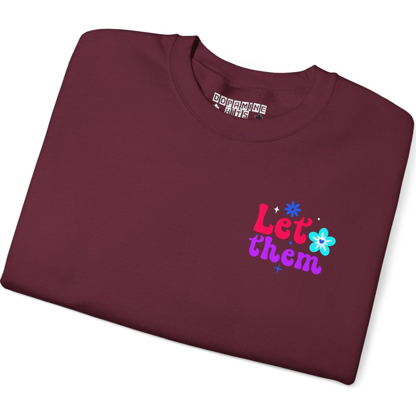 Folded maroon t-shirt with colorful text and graphics on a white background