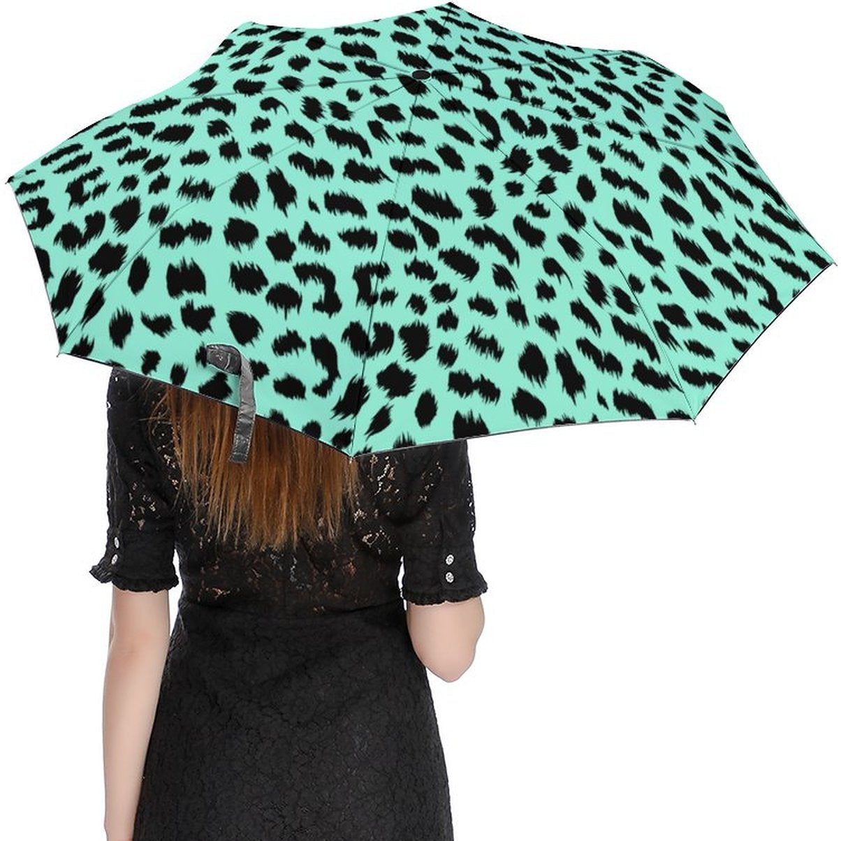 Person holding a green umbrella with black leopard print pattern on a white background