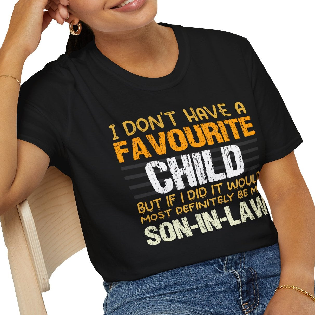 Person wearing a black t-shirt with humorous text design, sitting on a chair.