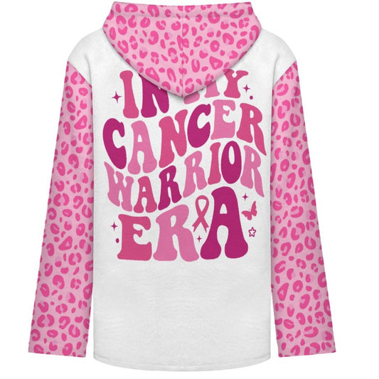 A white long-sleeve hoodie with pink leopard print sleeves and hood, featuring the text 'IN MY CANCER WARRIOR ERA' in pink retro lettering with a pink ribbon on the back.