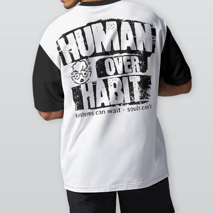 Person wearing a white and black t-shirt with 'Human Over Habit' text on the back, standing against a plain background.