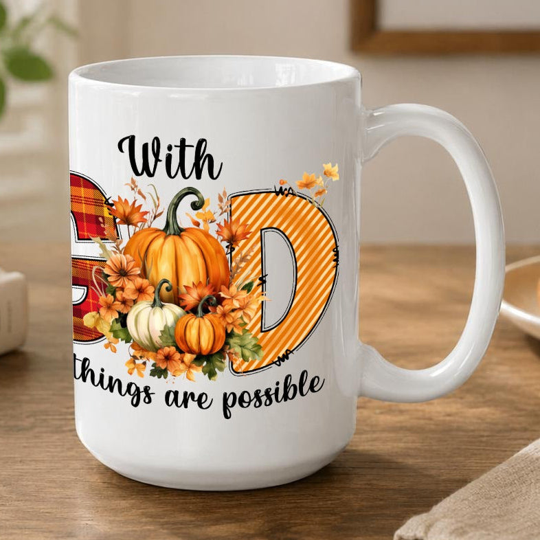 A white ceramic coffee mug with a 'With Good things are possible' autumn graphic, sitting on a wooden table in a cozy, well-lit room.