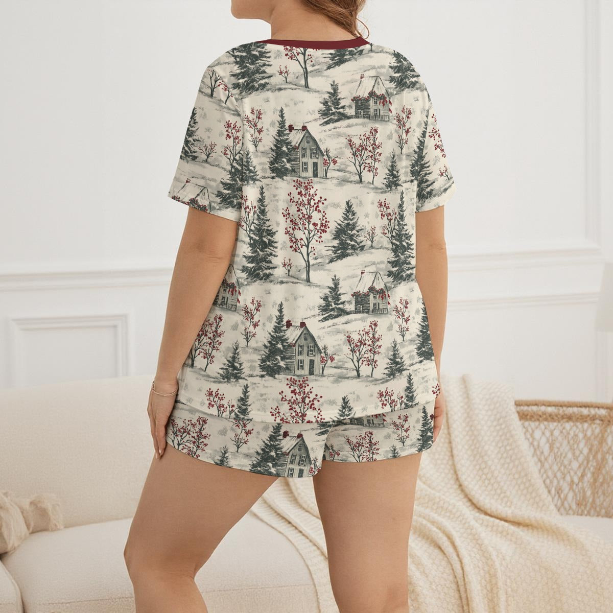 Person wearing a matching pajama set with a winter landscape pattern in a cozy room.