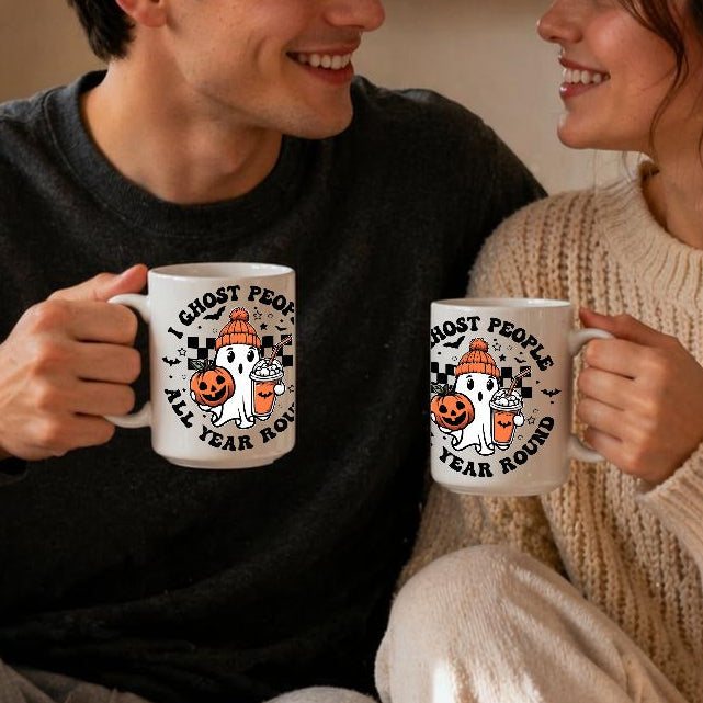 Two people sitting together holding mugs with a cozy indoor setting.
