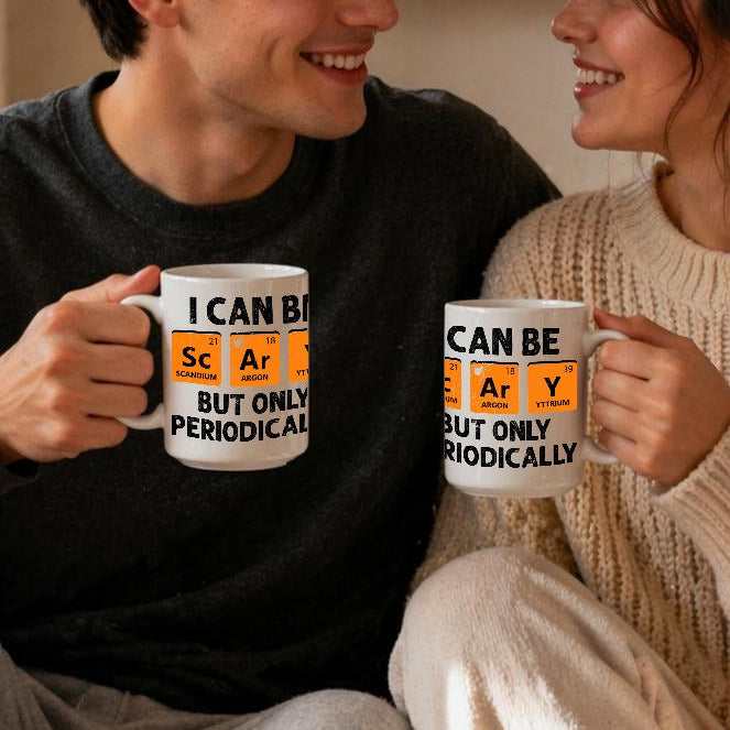 Two people sitting together holding mugs with a cozy indoor setting.