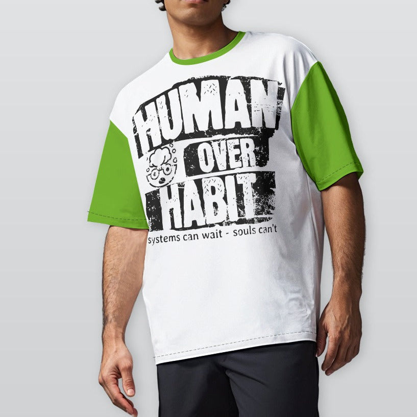 Person wearing a white and green t-shirt with 'Human Over Habit' text on a plain background