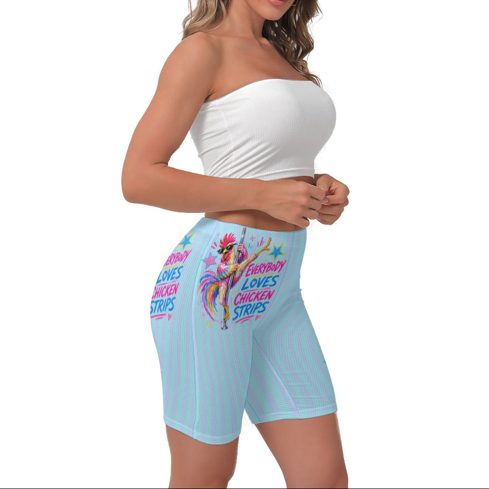 A woman modeling light blue and cyan biker shorts with a colorful graphic print of a cartoon chicken and the text 'EVERYBODY LOVES CHICKEN STRIPS!'. She is also wearing a white strapless crop top against a plain white background.
