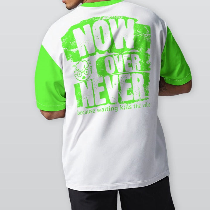 Person wearing a white and green t-shirt with text on the back, standing against a plain background.