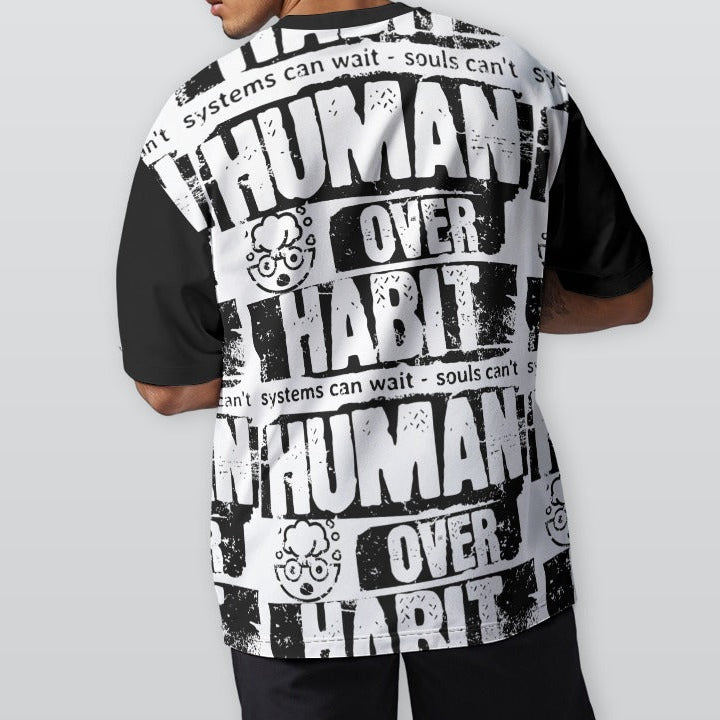 Person wearing a black and white graphic t-shirt with text on a plain background