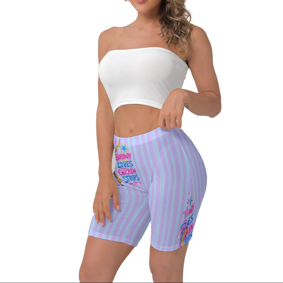 A woman modeling a white strapless crop top and light purple and blue  striped biker shorts with pink and blue graphic & text on the side, set against a plain white background.