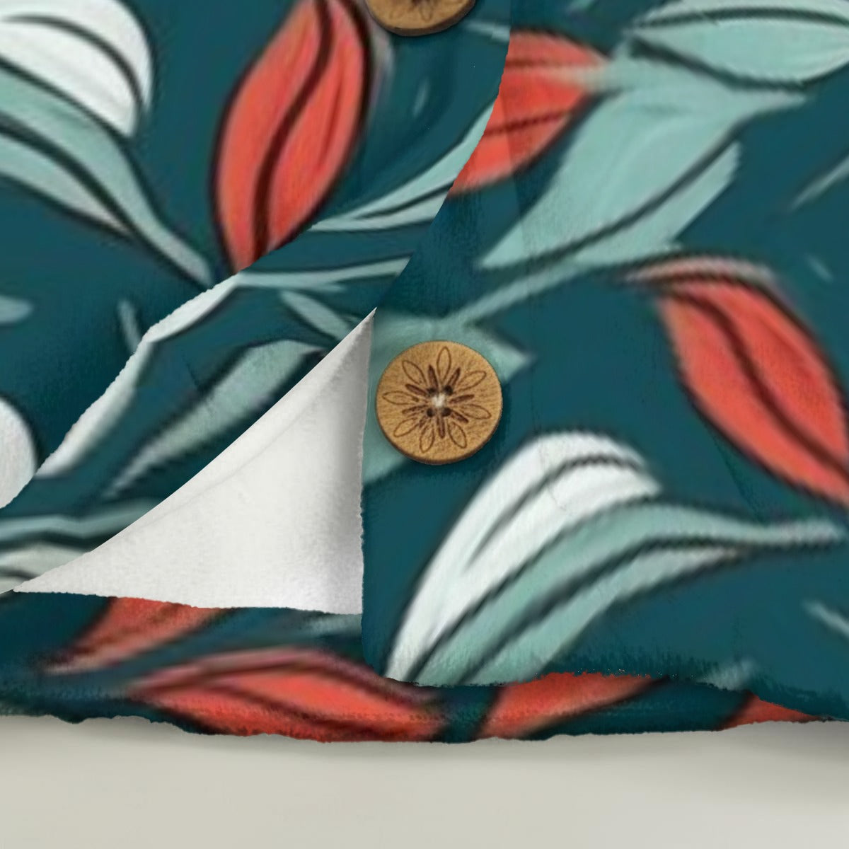 Close-up of a fabric with a colorful leaf pattern and decorative buttons.