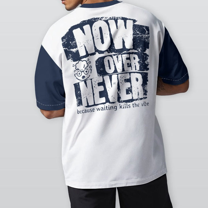 Person wearing a white and navy t-shirt with text on the back, standing against a plain background