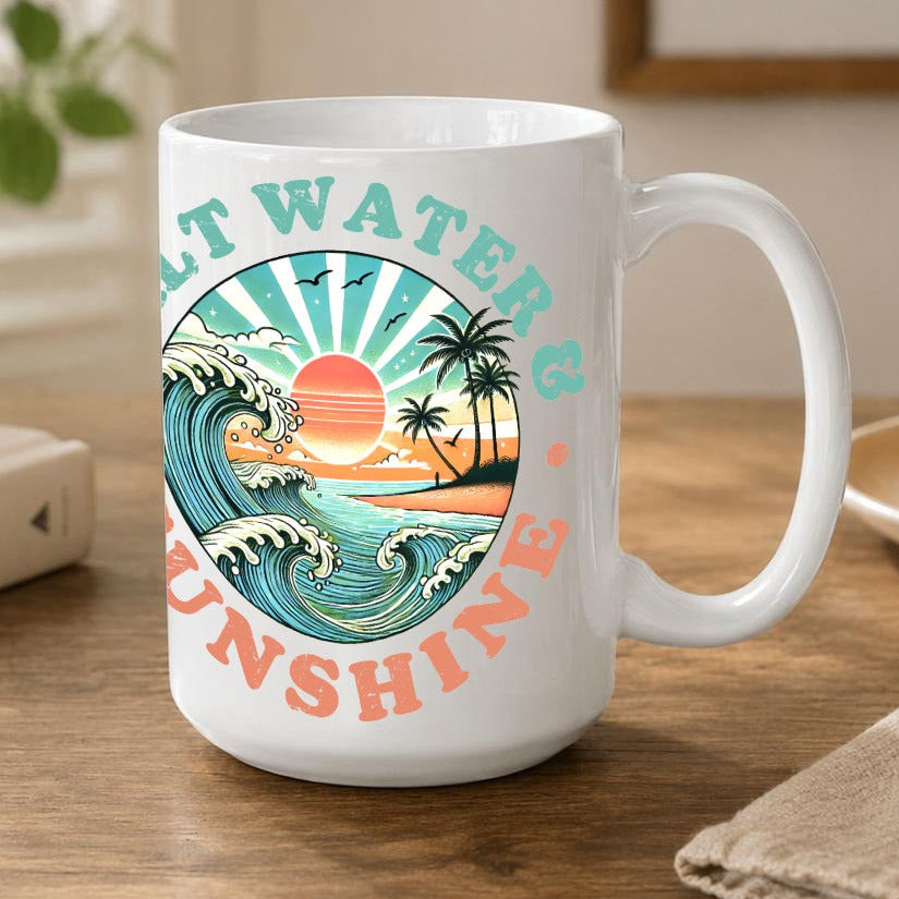 A white ceramic coffee mug with a colourful retro-style tropical wave graphic and the words 'Salt Water & Sunshine' printed on it, sitting on a wooden table in a cozy, sunlit room.
