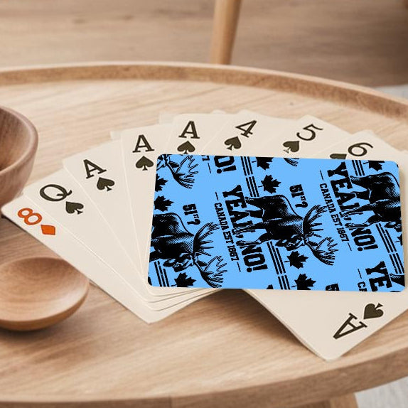 Wooden table with a bowl of lemons, a wooden spoon, and playing cards in a living room.