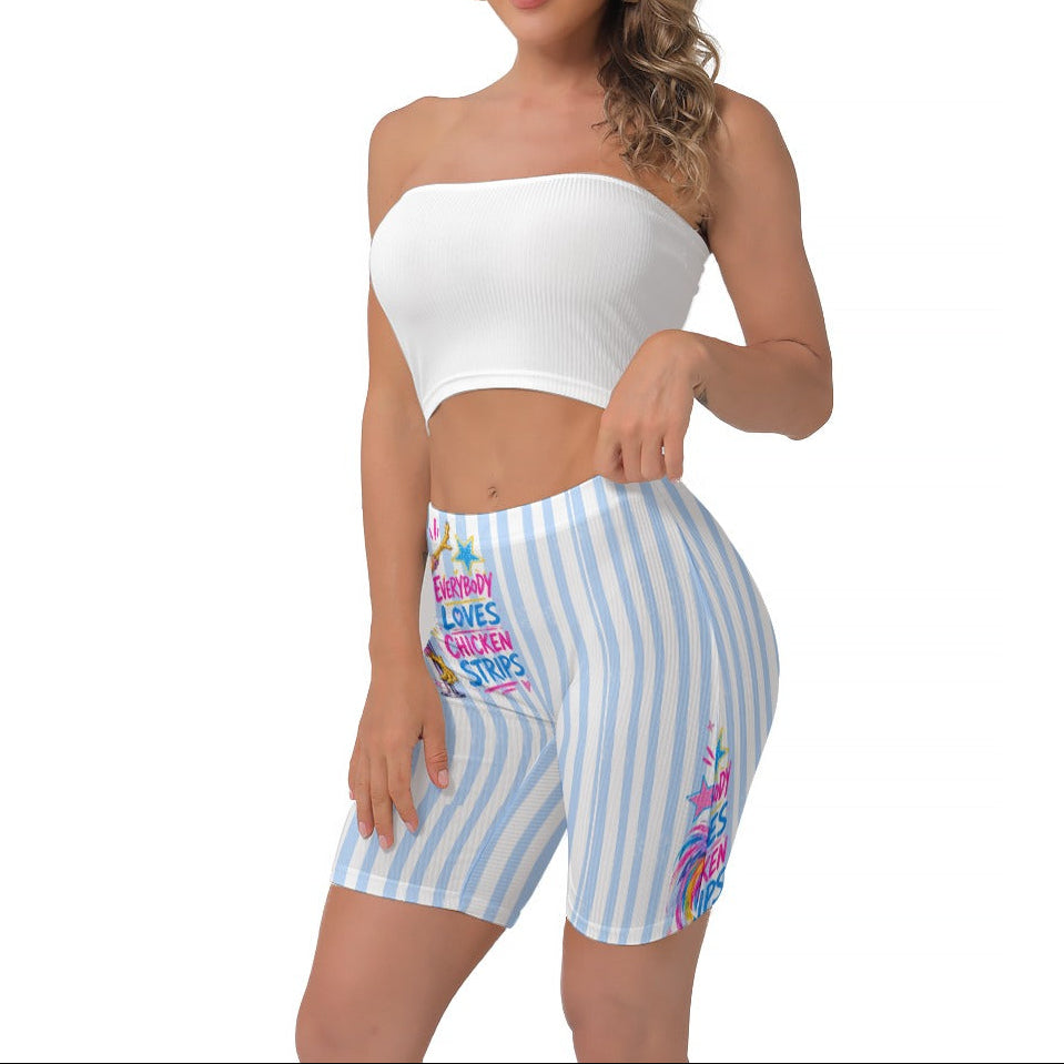 A woman modeling a white strapless crop top and light blue and white vertically striped biker shorts with colourful text and graphics on the front and side of the left leg.