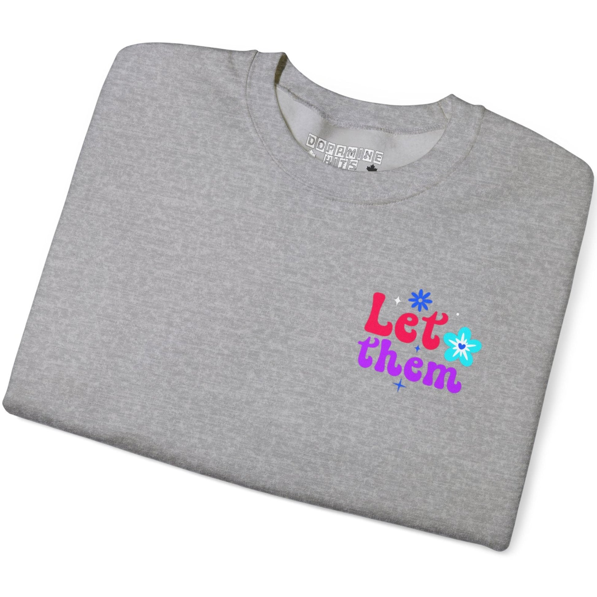 Folded gray t-shirt with colorful text and flower graphics on a white background
