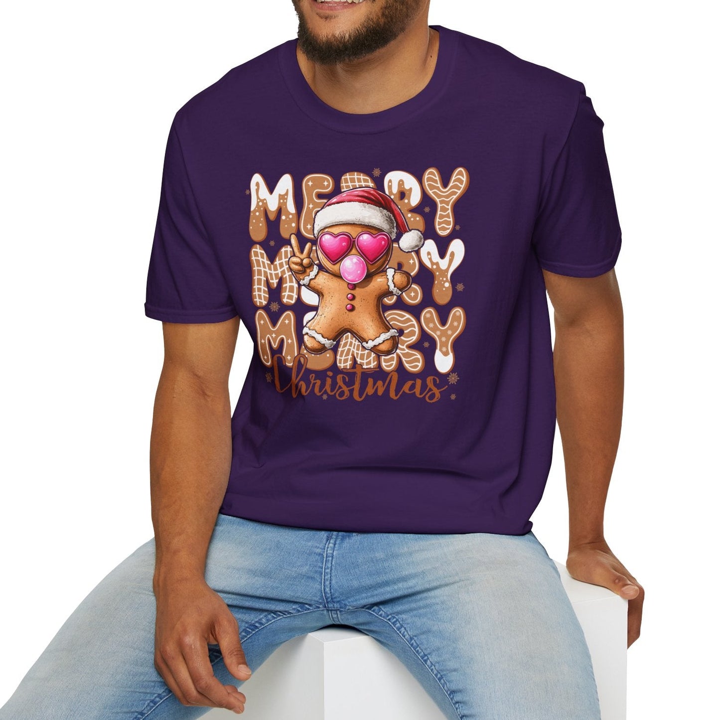 Man wearing a purple t-shirt with 'Merry Christmas' design sitting on a white stool.