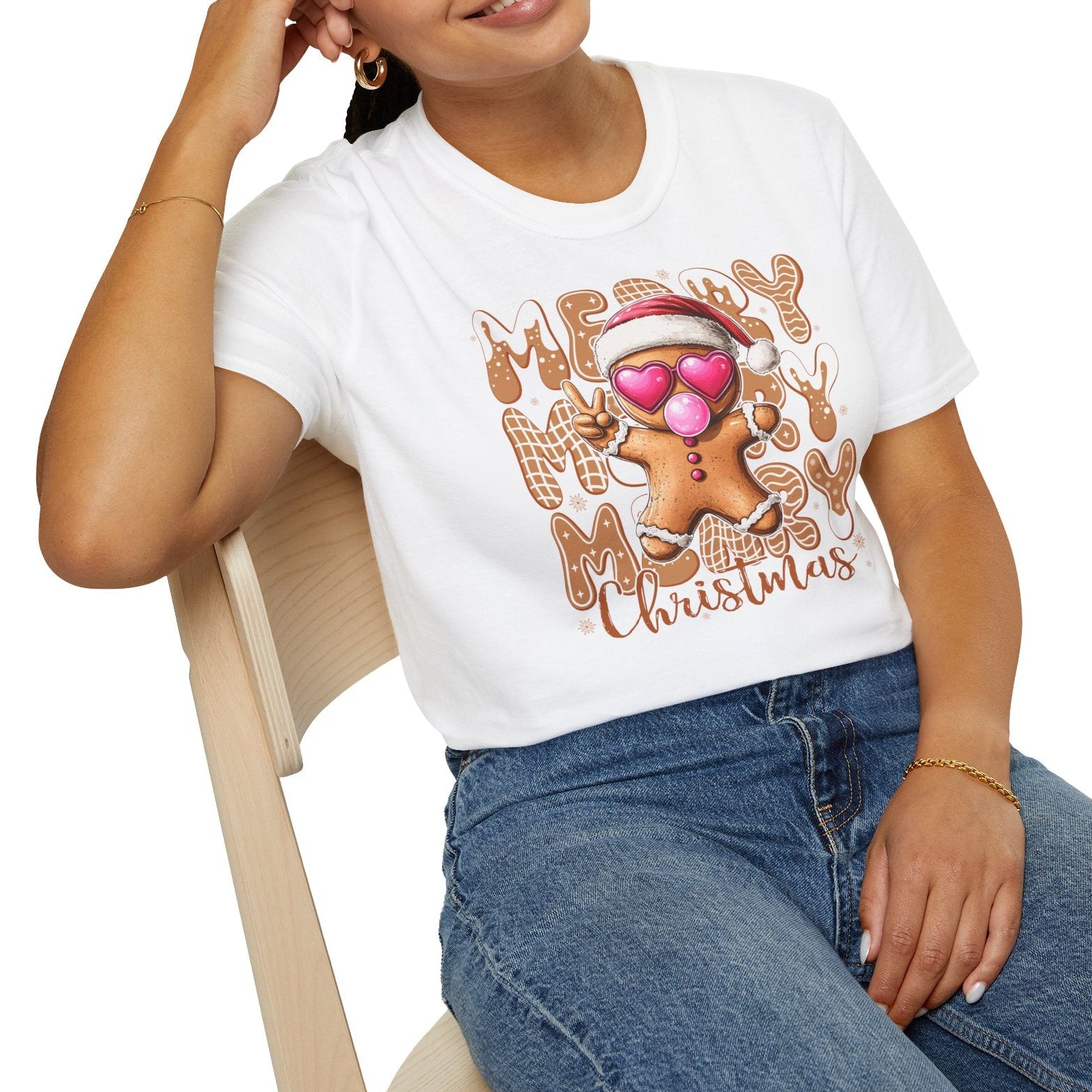 Woman wearing a white t-shirt with a gingerbread man design and 'Merry Christmas' text.