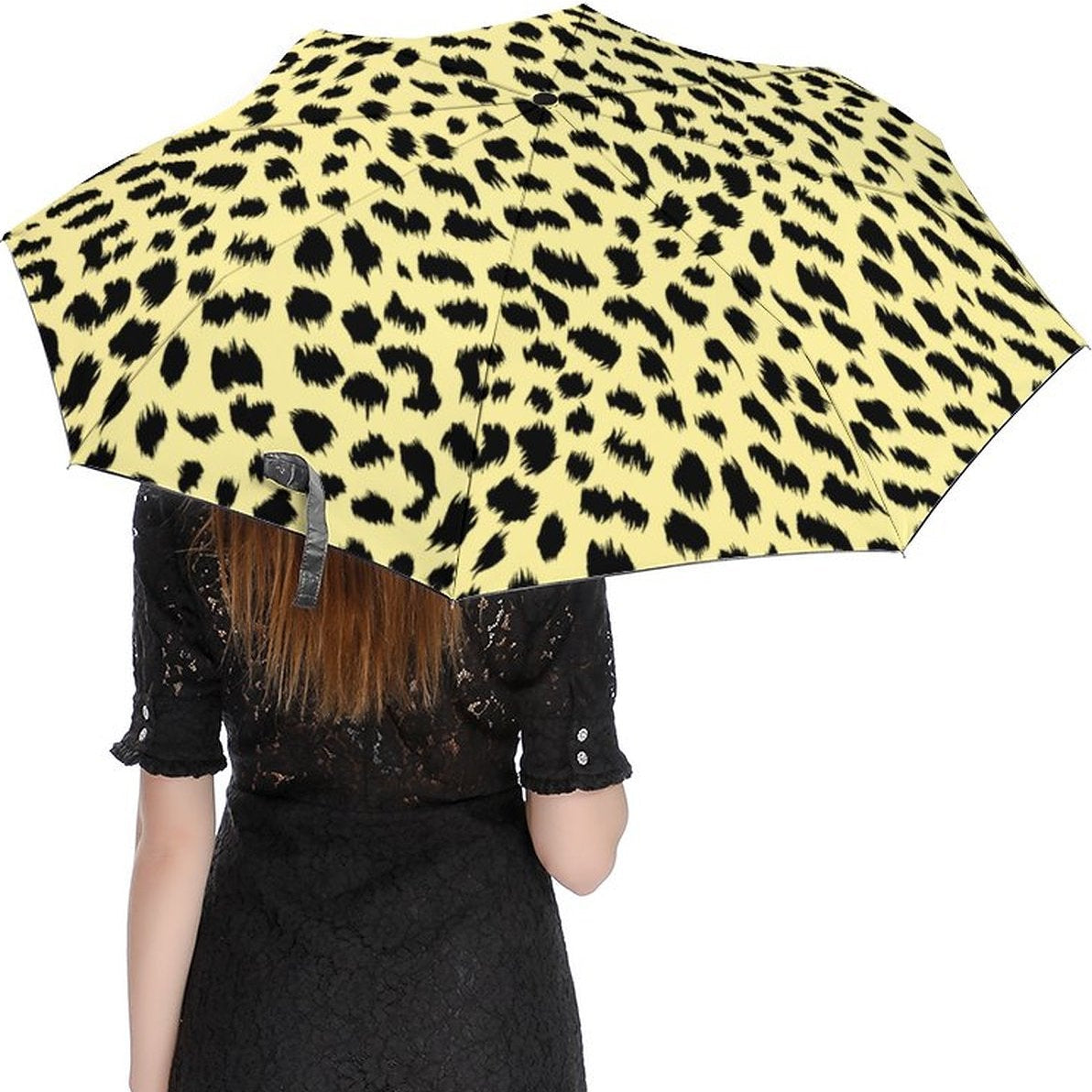 Person holding a yellow leopard print umbrella on a white background