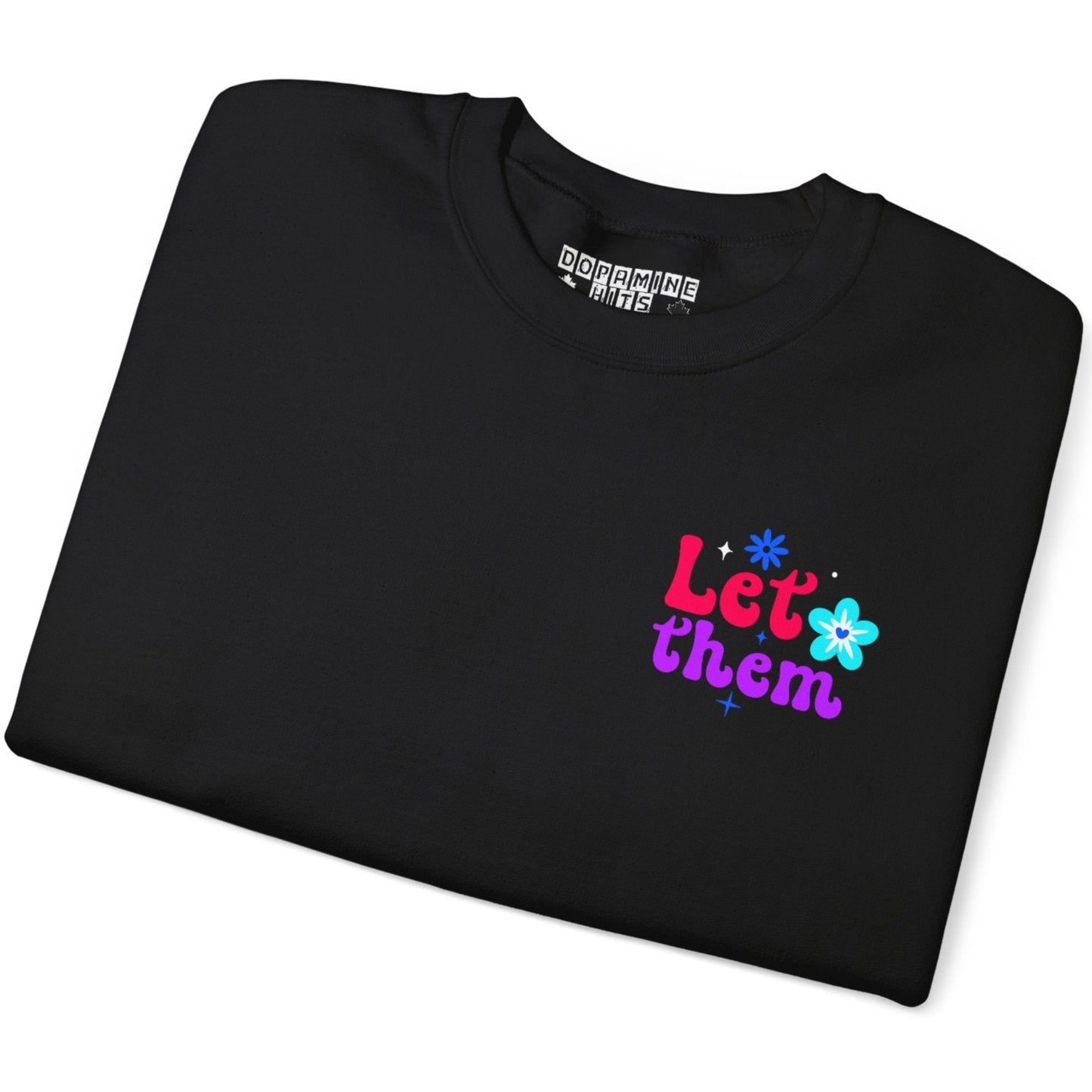 Folded black t-shirt with colorful text and flower design on a white background