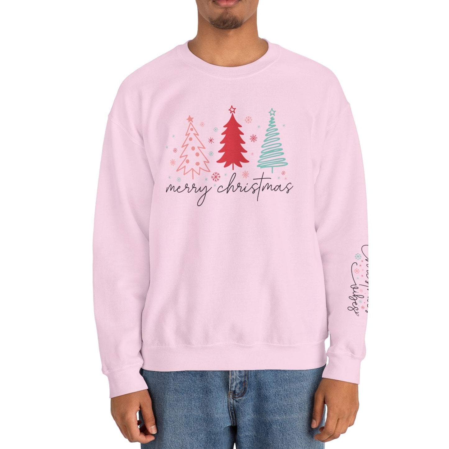 Person wearing a pink sweatshirt with Christmas tree design and 'merry christmas' text on a white background