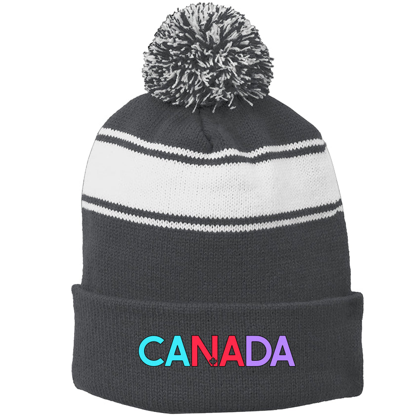 Charcoal and white striped beanie with pom-pom and 'CANADA' in colorful letters on a white background