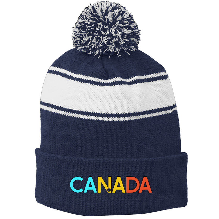 Navy and white beanie with pom-pom and 'Canada' embroidered on a white background